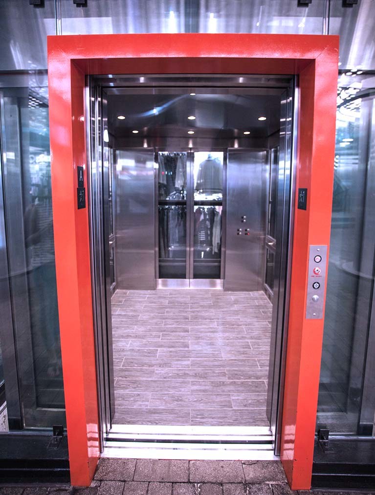 850 Third Ave, Brooklyn, glass elevators with black steel girders & orange accent door frames