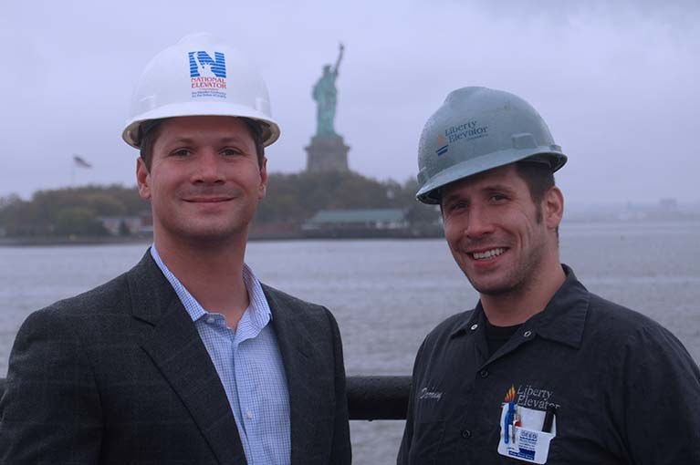 Doug & Darren Muttart of Liberty Elevator with the Statue of Liberty in the background